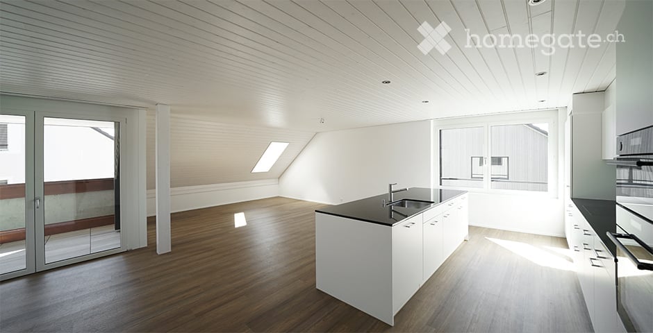 Modern kitchen with white cabinets, black countertops, and a central island. Features a sleek sink and faucet, with wooden flooring and large windows allowing natural light.