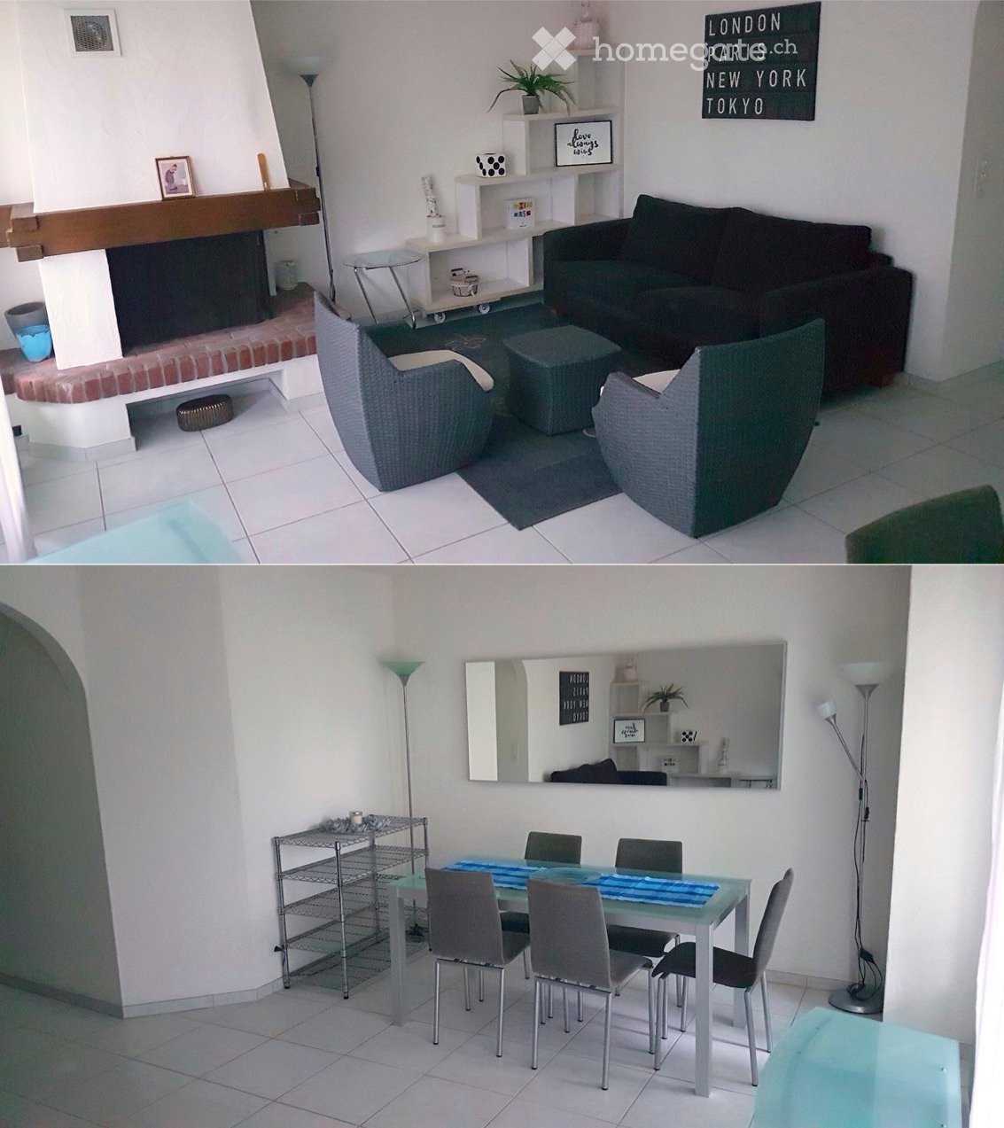 The image shows a modern living room and dining area. The living room features a dark-colored sofa, ottoman, and wicker chairs, along with a fireplace and decorative shelves. The dining area includes a glass table with six chairs and a metal shelving unit
