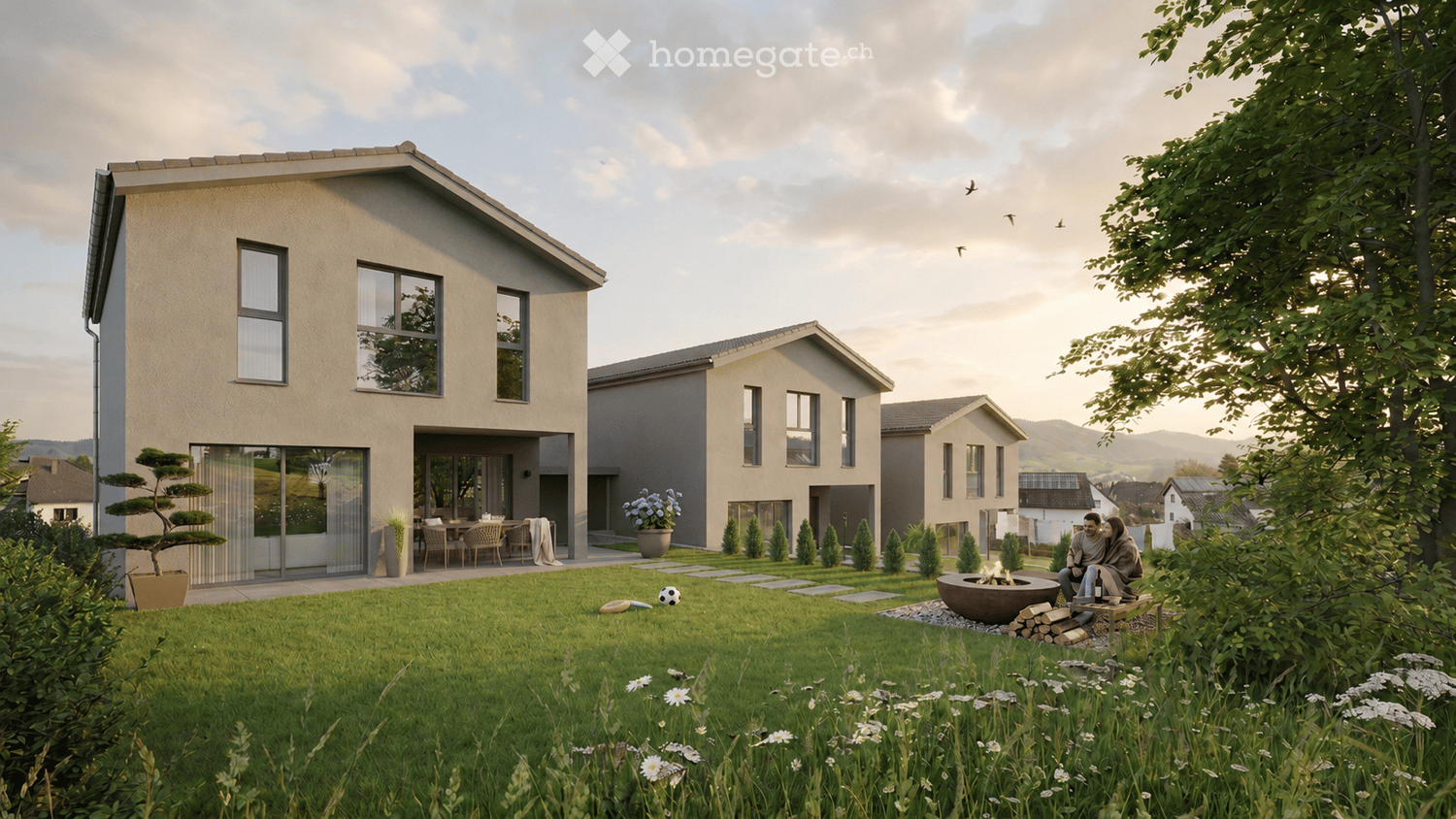 Modern two-story house with large windows, a spacious front yard, and a well-maintained garden. The house features a balcony and a patio area with outdoor furniture.