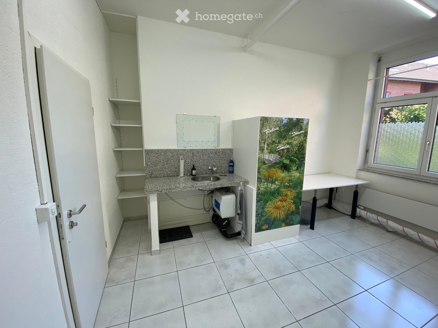 Bathroom with tiled floor, granite countertop, sink, mirror, and a small table near the window.