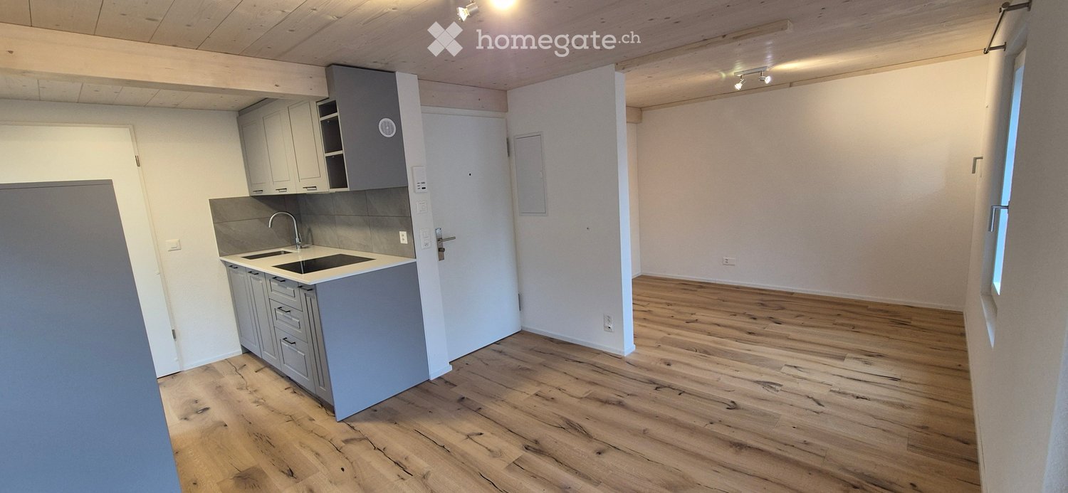 kitchen with wooden floor, white walls, built-in appliances, sink, faucet, and cabinets