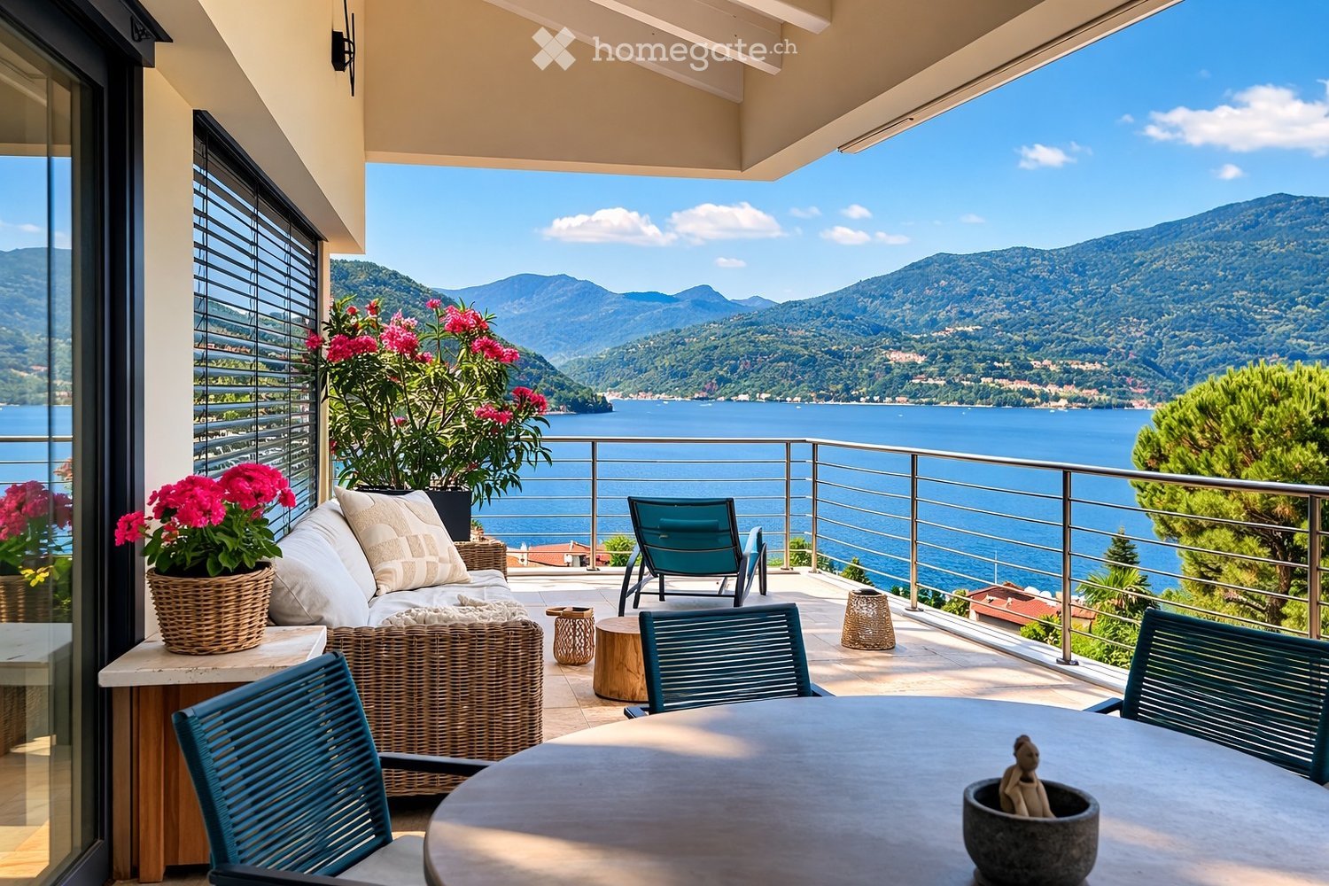 Balcony with a table and chairs, flowers, a couch, and a view of the sea and mountains