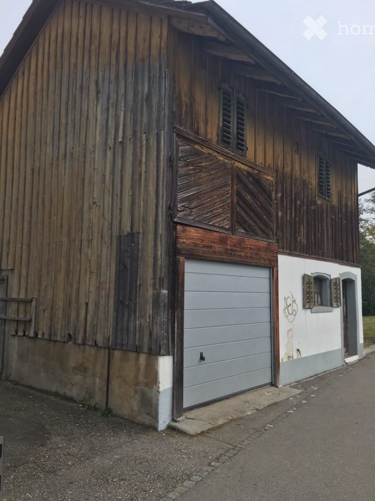 Old wooden house, garage, white wall, wooden shutters, graffiti