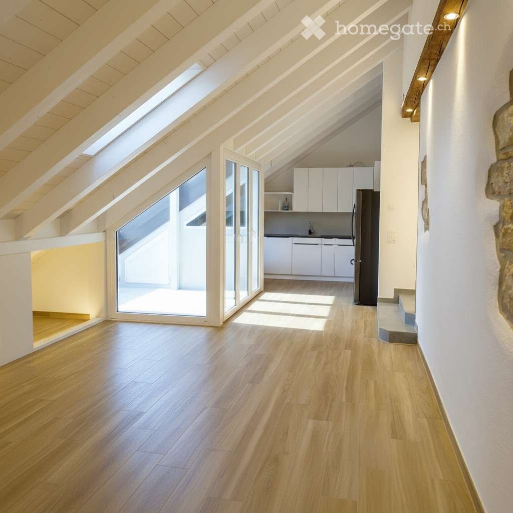 Bright, airy attic space with wooden flooring, large skylights, and a modern kitchen area featuring white cabinets and a refrigerator.