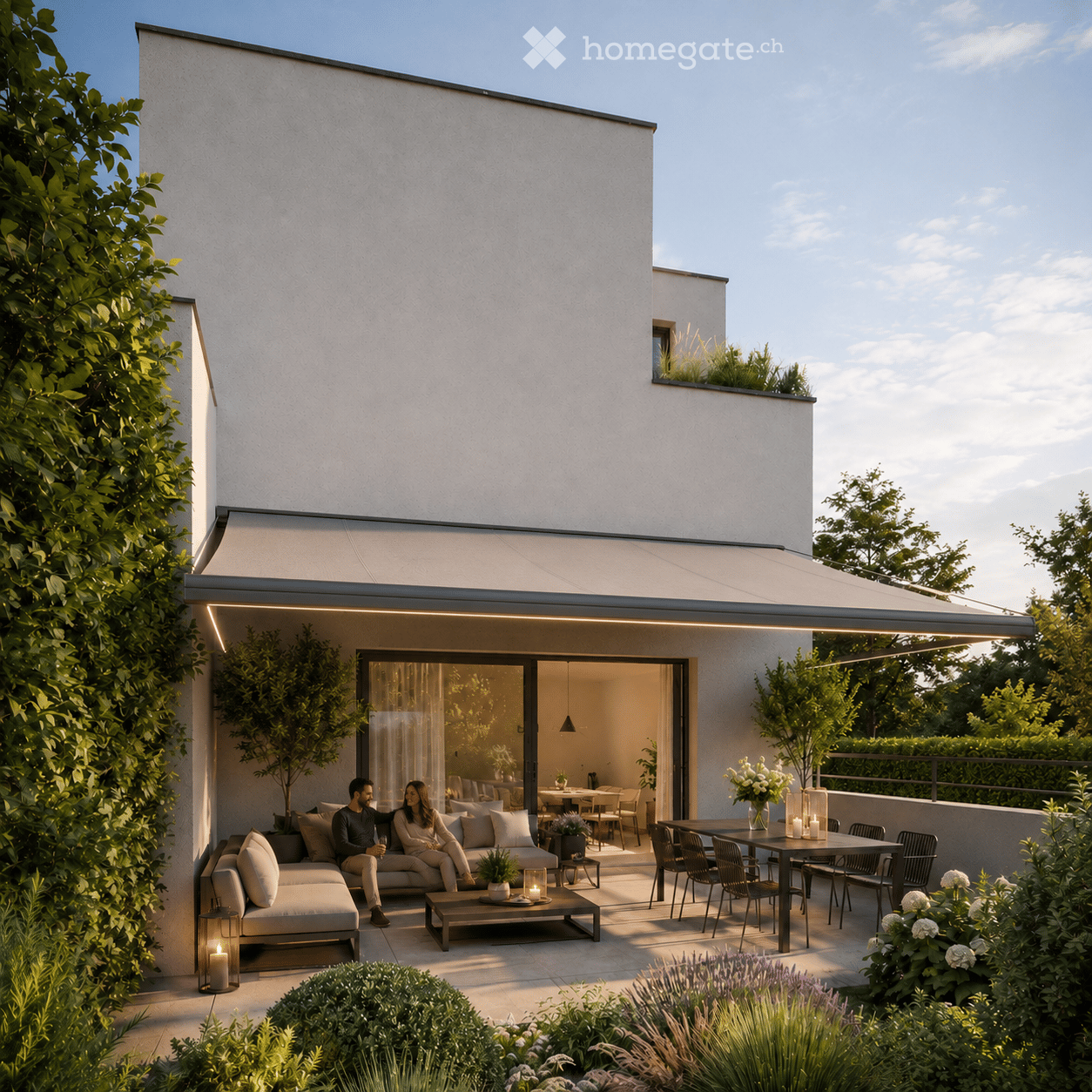 Garden / Outdoor Area. Modern outdoor patio with a covered seating area, sofa, coffee table, dining table, and chairs. The space features lush greenery, candles, and a view of the interior dining area through large glass doors.