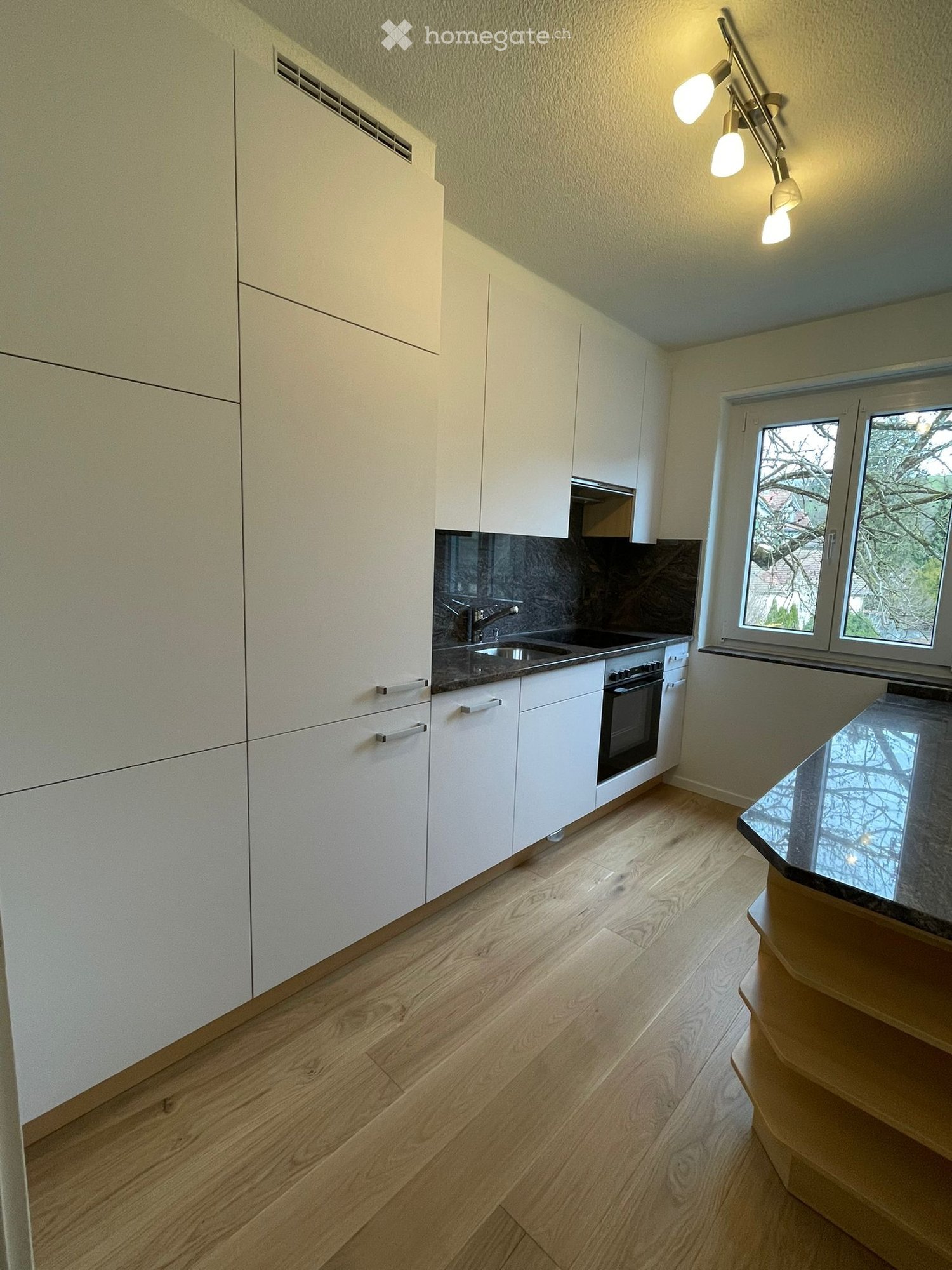 modern kitchen with white cabinets, wooden floor, granite countertop, sink, oven, window