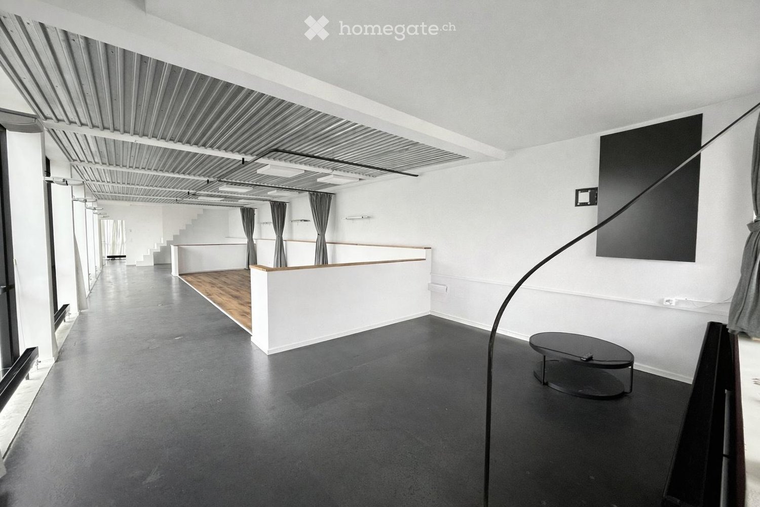 Empty room, black floor, white walls, wooden floor, black table, metal railing, black curtains