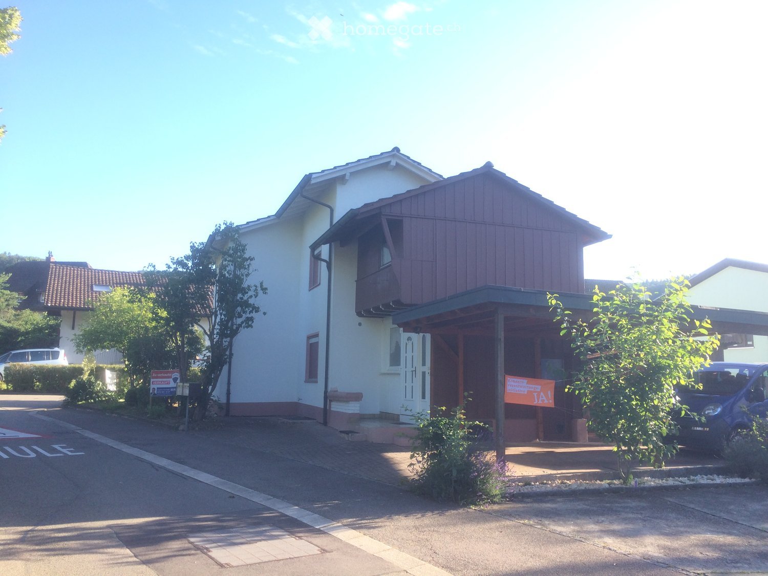 Two-story house, white exterior, brown roof, balcony, covered entrance, fenced yard