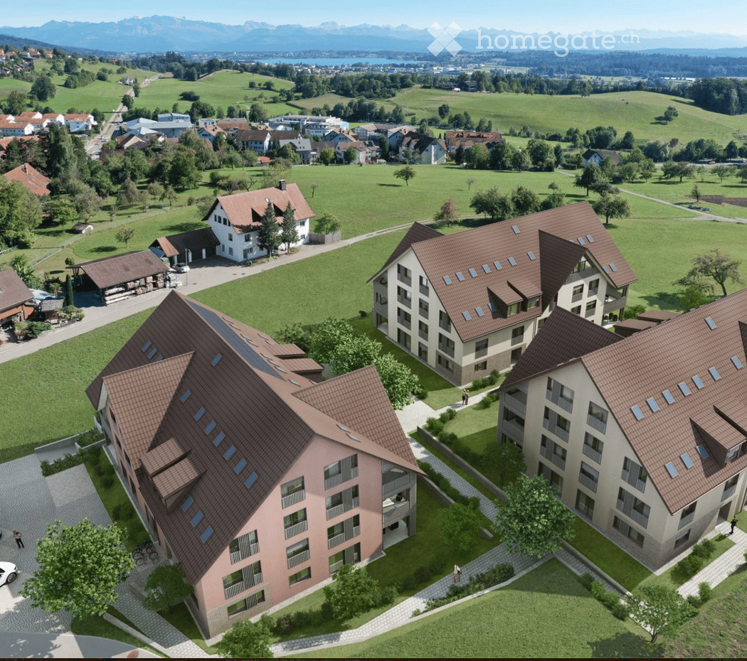 3 residential buildings, brown roofs, solar panels, green surroundings, mountains in the background