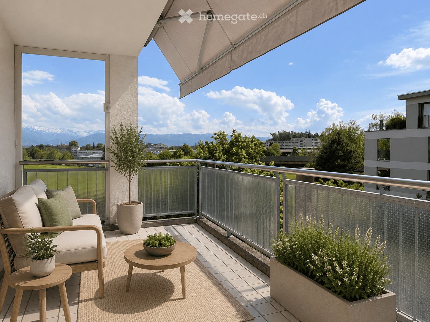 Balcony with a sofa, small table, chairs, and potted plants, overlooking a scenic view of mountains and a green field.