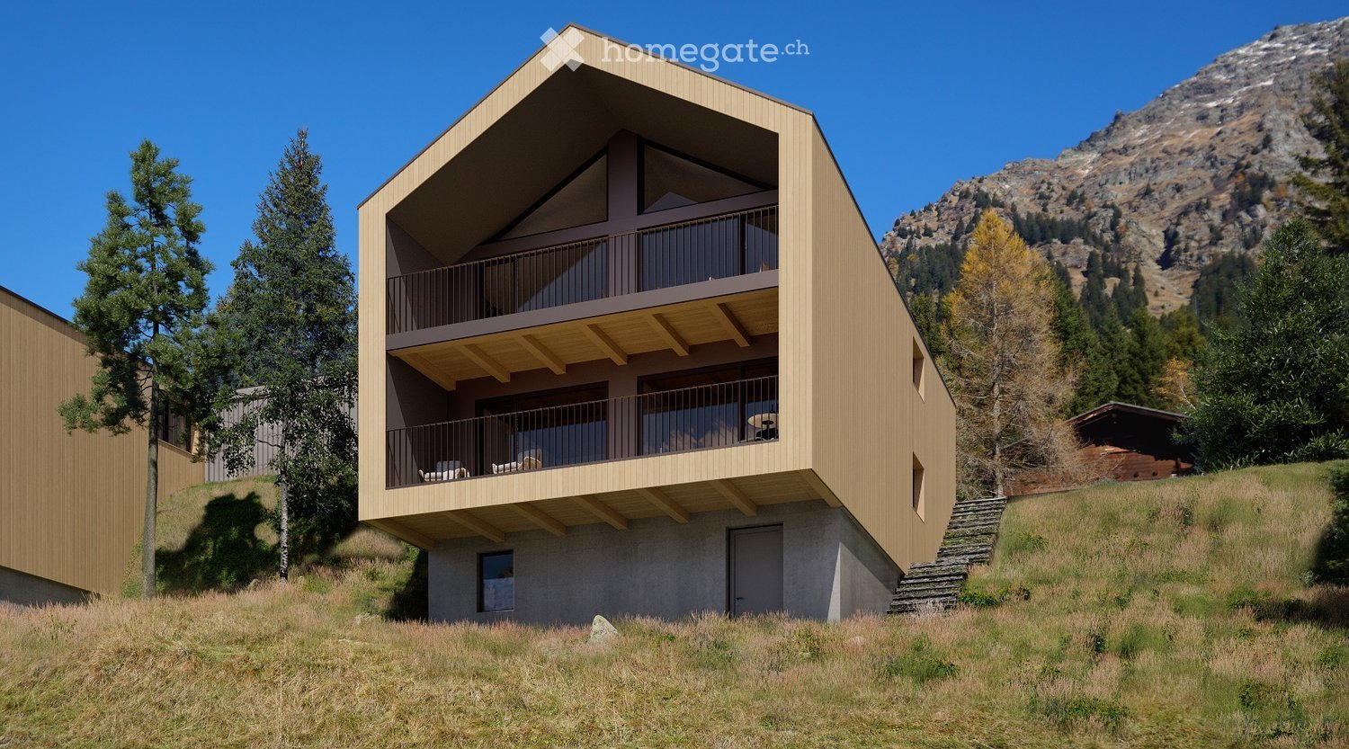 Modern two-story wooden house with balconies, situated on a grassy slope with a mountain backdrop.