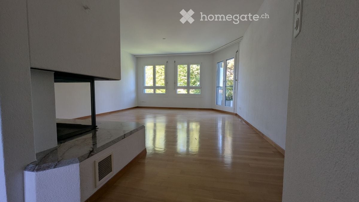 Empty room with wooden flooring, white walls, and large windows allowing natural light. No furniture or equipment present.