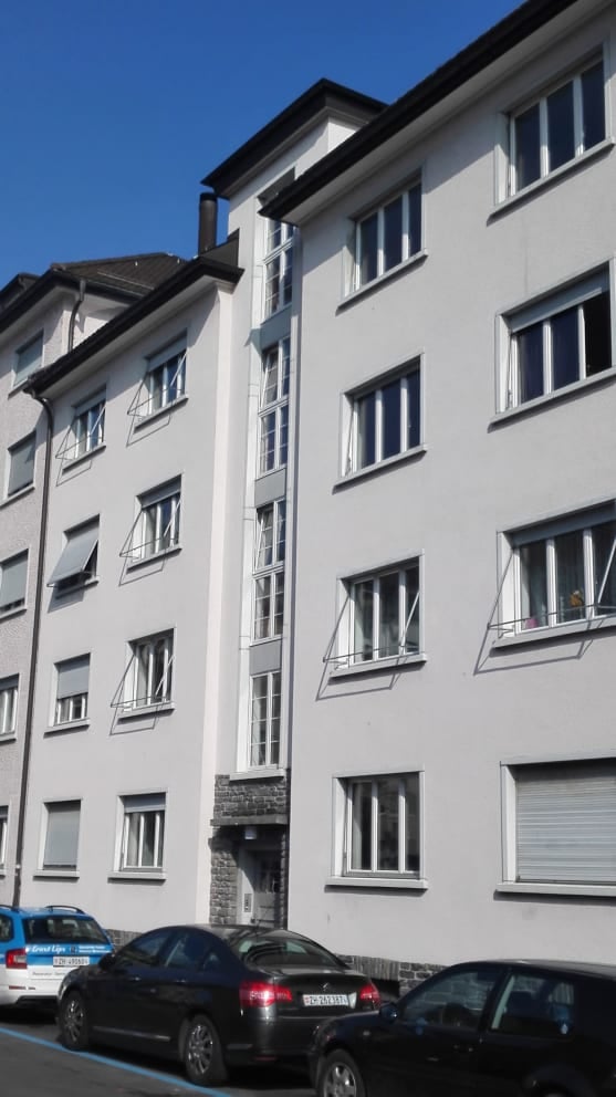 White painted building with 4 floors and 12 apartments, with balconies