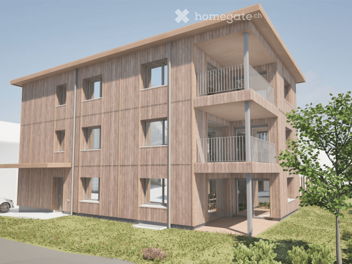 Modern two-story wooden building with multiple balconies and large windows, surrounded by greenery.