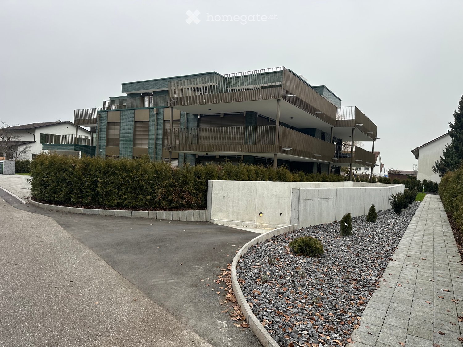 2 story house, multiple balconies, grey walls, concrete barriers