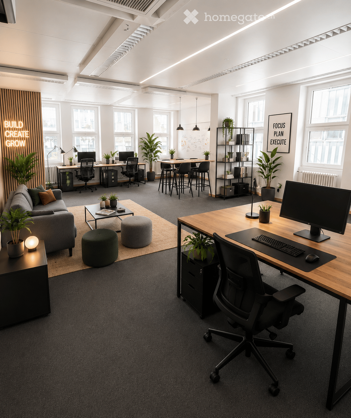 Modern office space with a mix of seating and workstations, featuring a grey sofa, coffee table, round stools, desks, chairs, computer screens, keyboards, mice, lamps, and shelves.