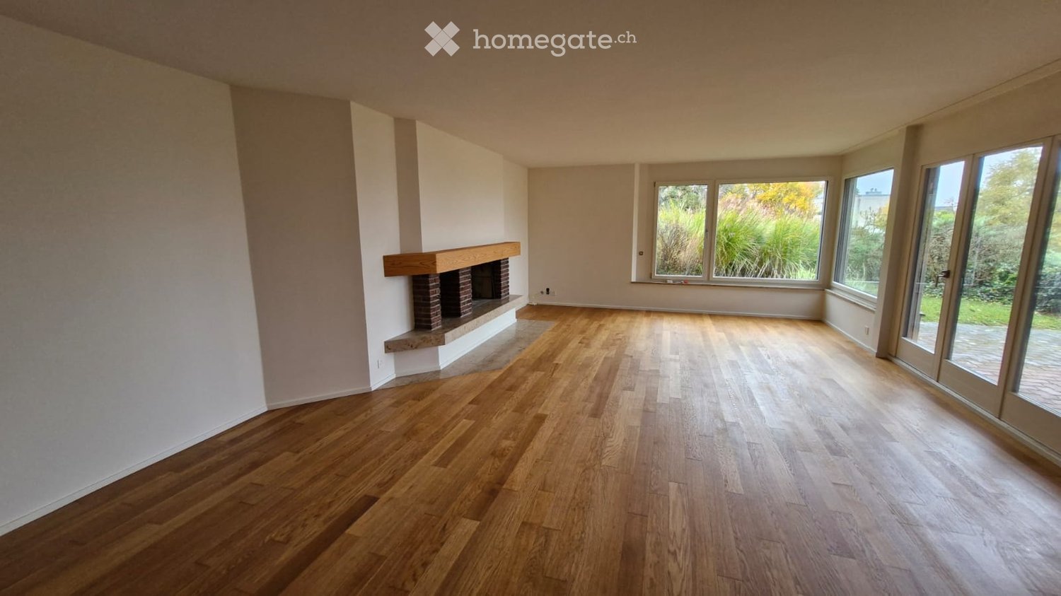 wooden floor, fireplace, white walls, large windows