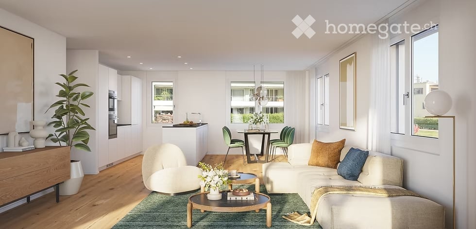 Modern, open-concept living and dining area with light wood flooring, white walls, large windows, and a mix of contemporary furniture including a white sectional sofa, a round coffee table, a dining table with chairs, and a kitchen island.