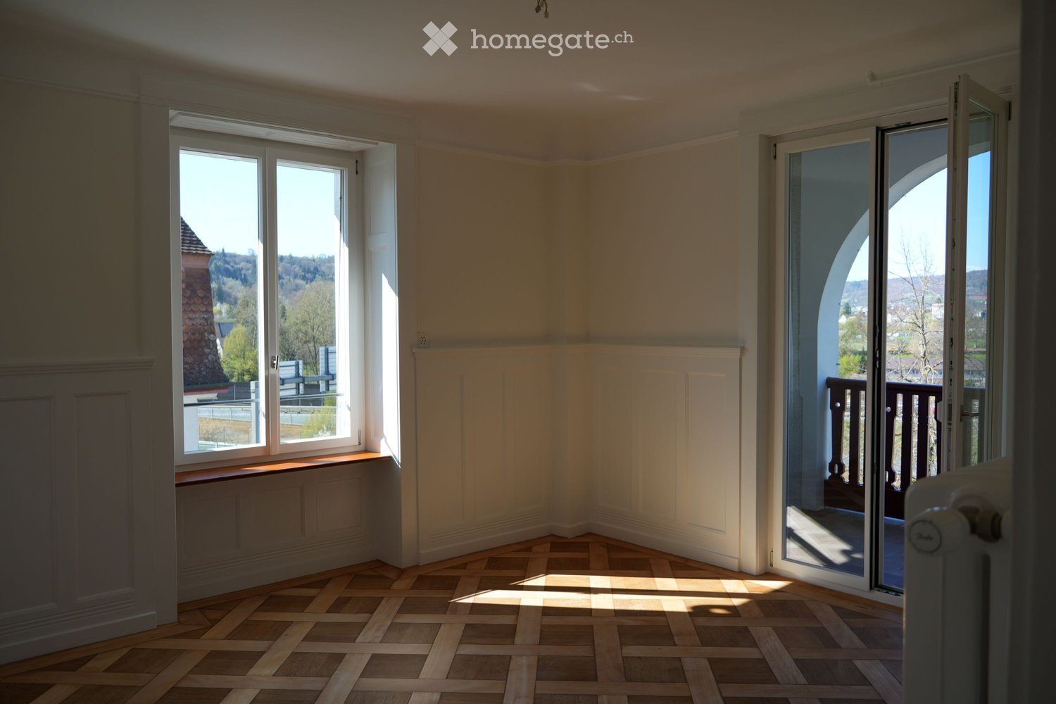 empty room, wooden parquet floor, white walls, large windows, balcony