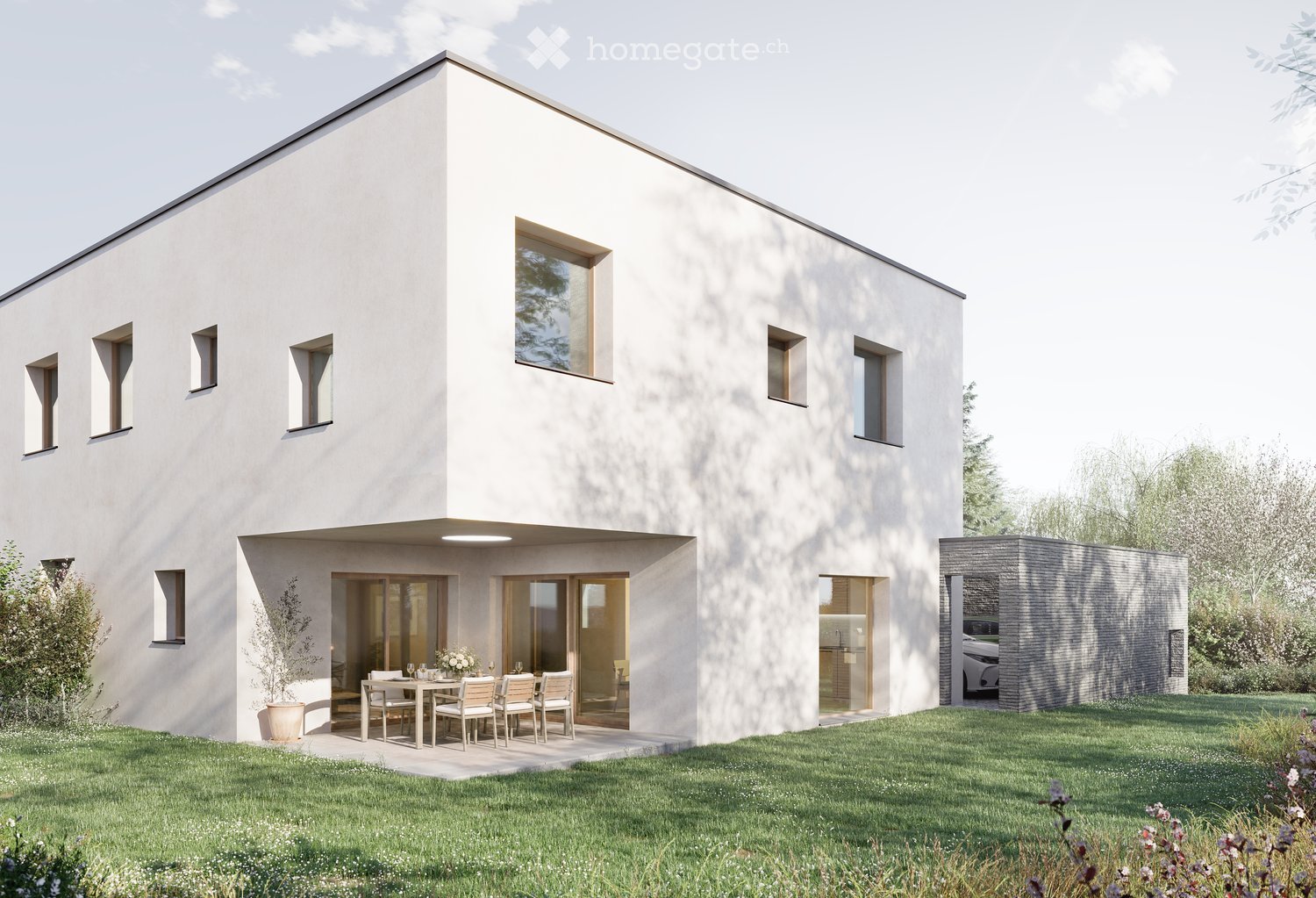 Modern two-story house with white exterior, large windows, and a raised ground floor. Features a patio area with a dining table and chairs, a small garden, and a garage with a parked car.