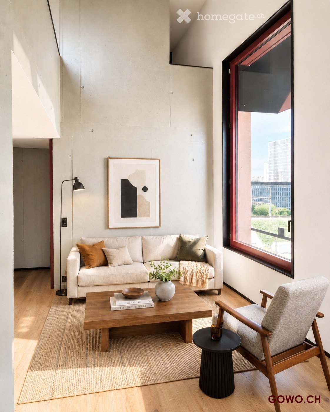 Modern living room with a light-colored sofa, wooden coffee table, armchair, and a large window offering a city view.