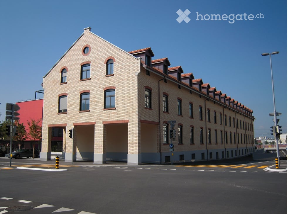 3 story building, brick walls, multiple windows, garage entrance, street lights