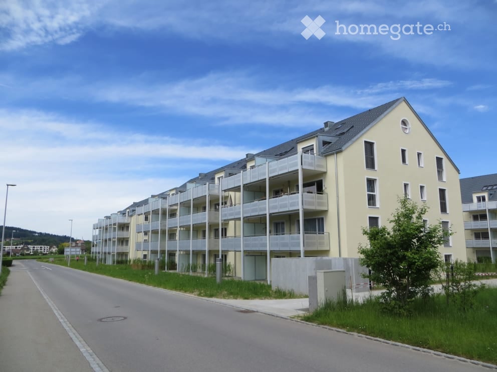 Modern multi-story apartment building with balconies and a clean, contemporary design.