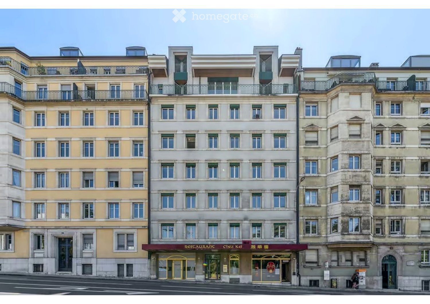 Multi-story building with classic European architecture, featuring multiple windows, balconies, and a ground-floor restaurant entrance.