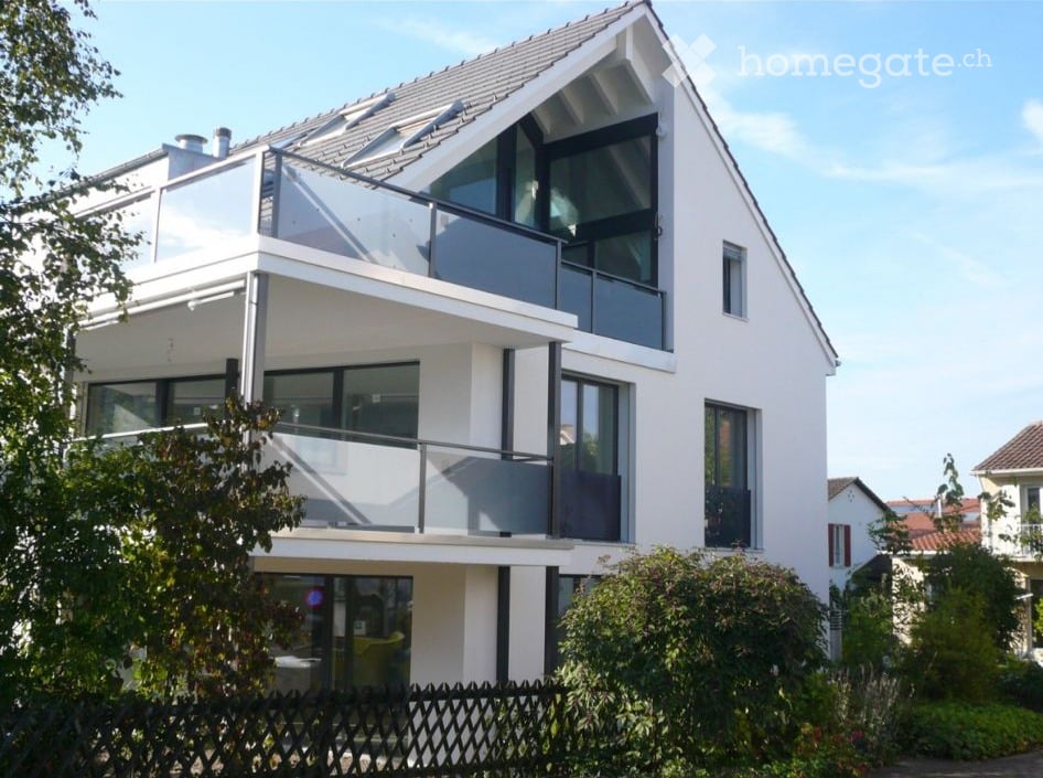 Modern two-story house with white exterior, large windows, and balconies.