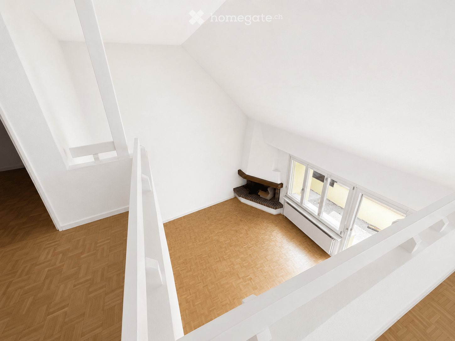 Bright, minimalist hallway with wooden herringbone flooring, white walls, and a small built-in bench with a fireplace. Large windows provide natural light.