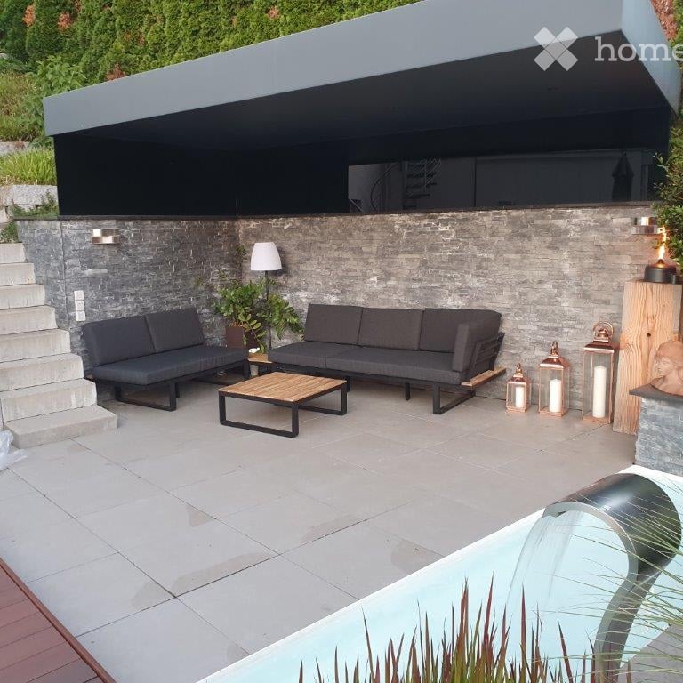Swimming pool, sitting area with 2 sofas, 1 table, 3 lanterns, staircase, pergola