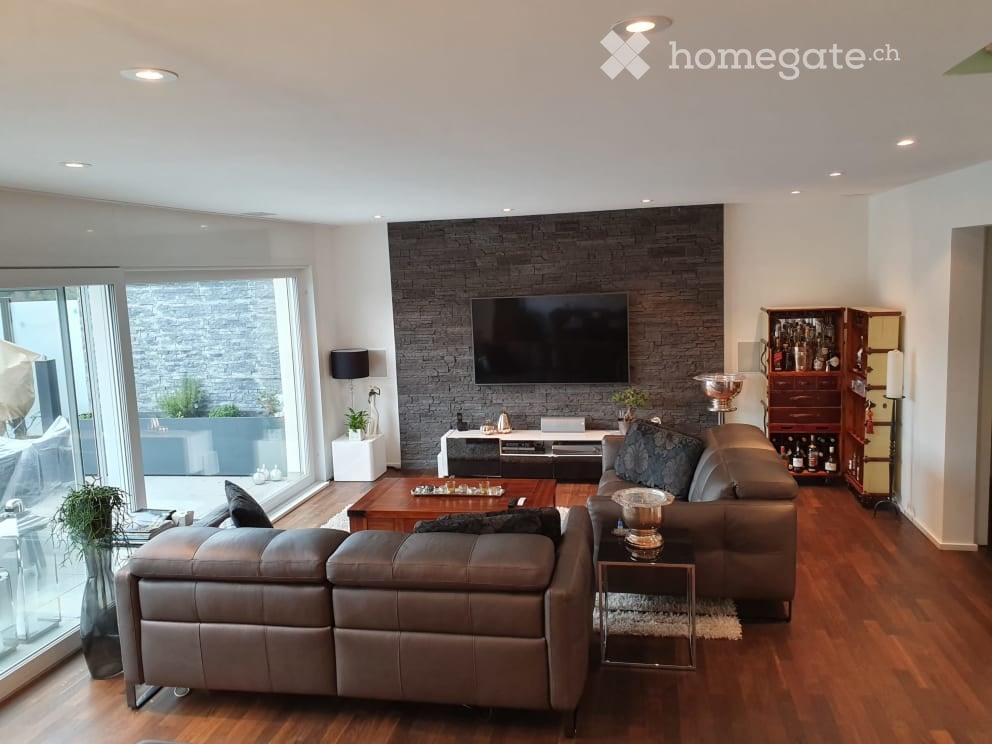 modern living room with wooden floor, big leather sofa, entertainment center with flat screen TV, decorative items