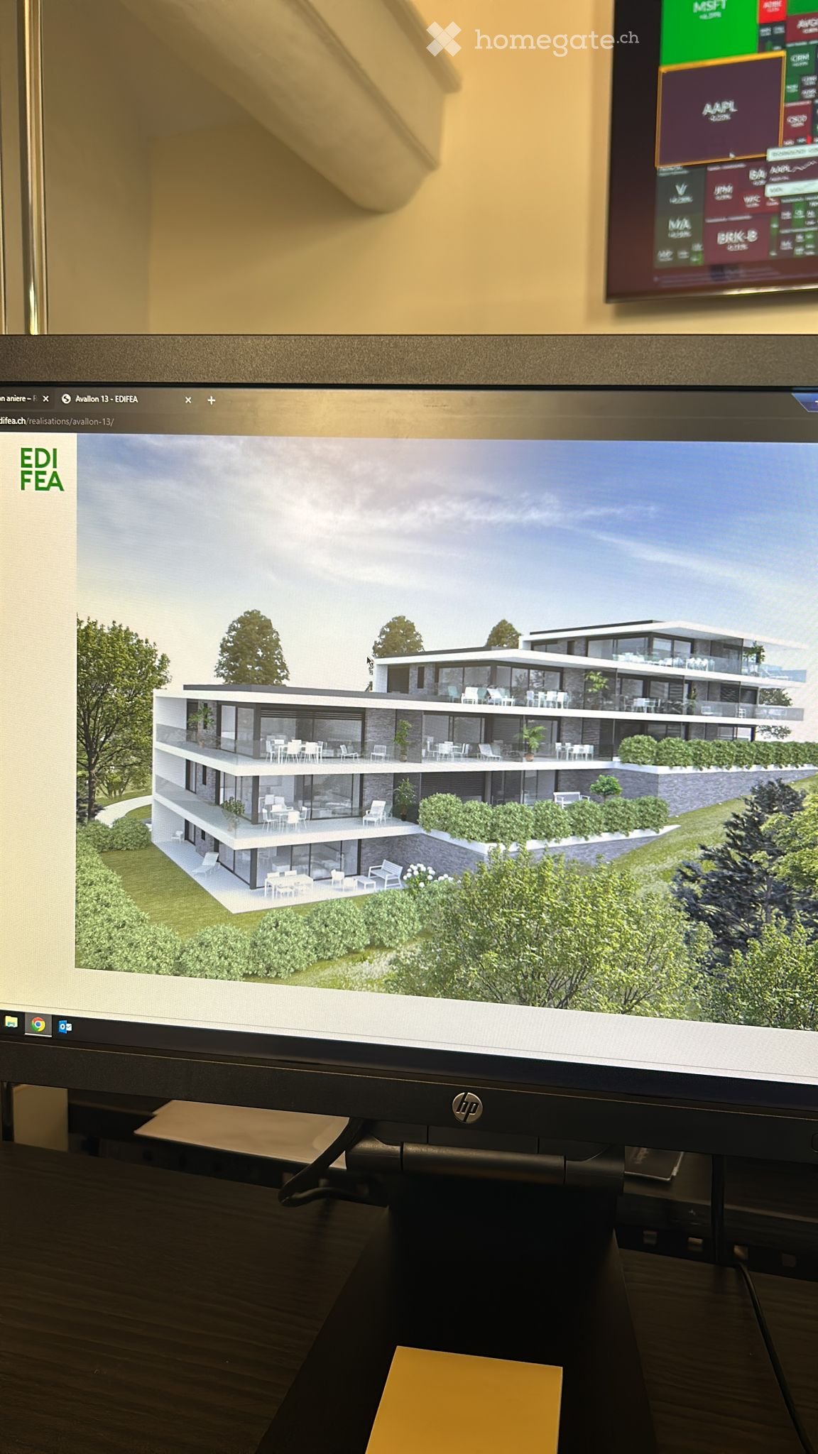 A 3D rendering of a modern two-story house with large windows, balconies, and outdoor seating areas, displayed on a computer screen.
