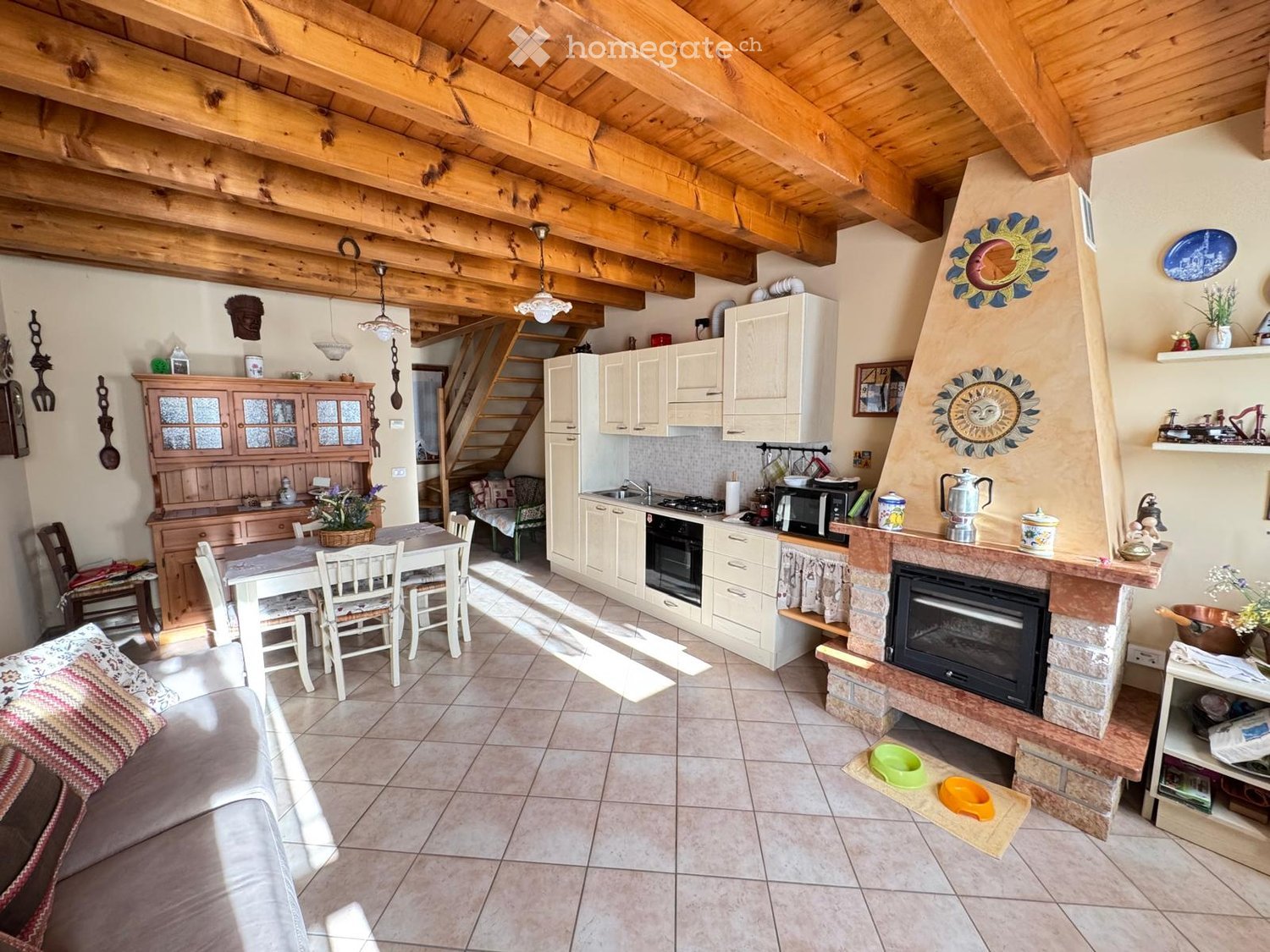 Open-plan living and dining area with a fireplace, kitchen, dining table, and seating area.