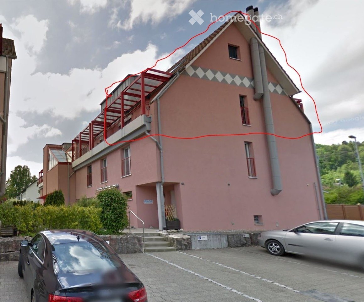Pink two-story house with a balcony, multiple windows, and a small staircase leading to the entrance.