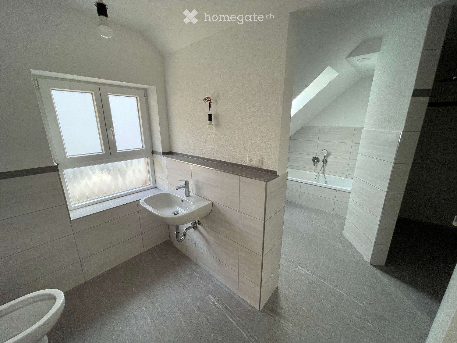 white sink, white toilet, grey tiled floor, white tiles, window, shower