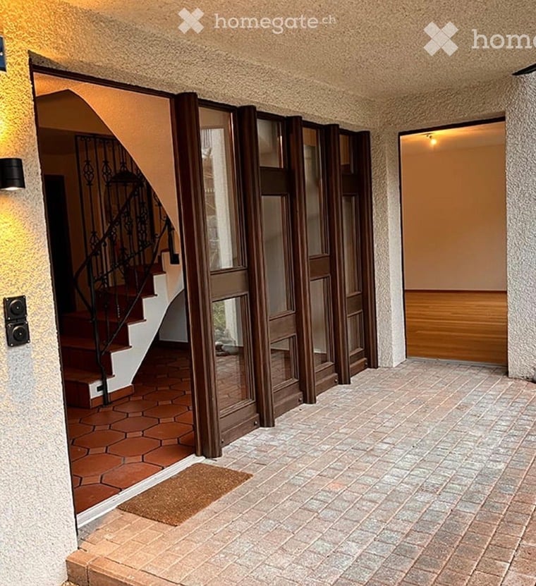 Entrance hallway with tiled floor, wooden sliding doors, and a staircase leading upwards.