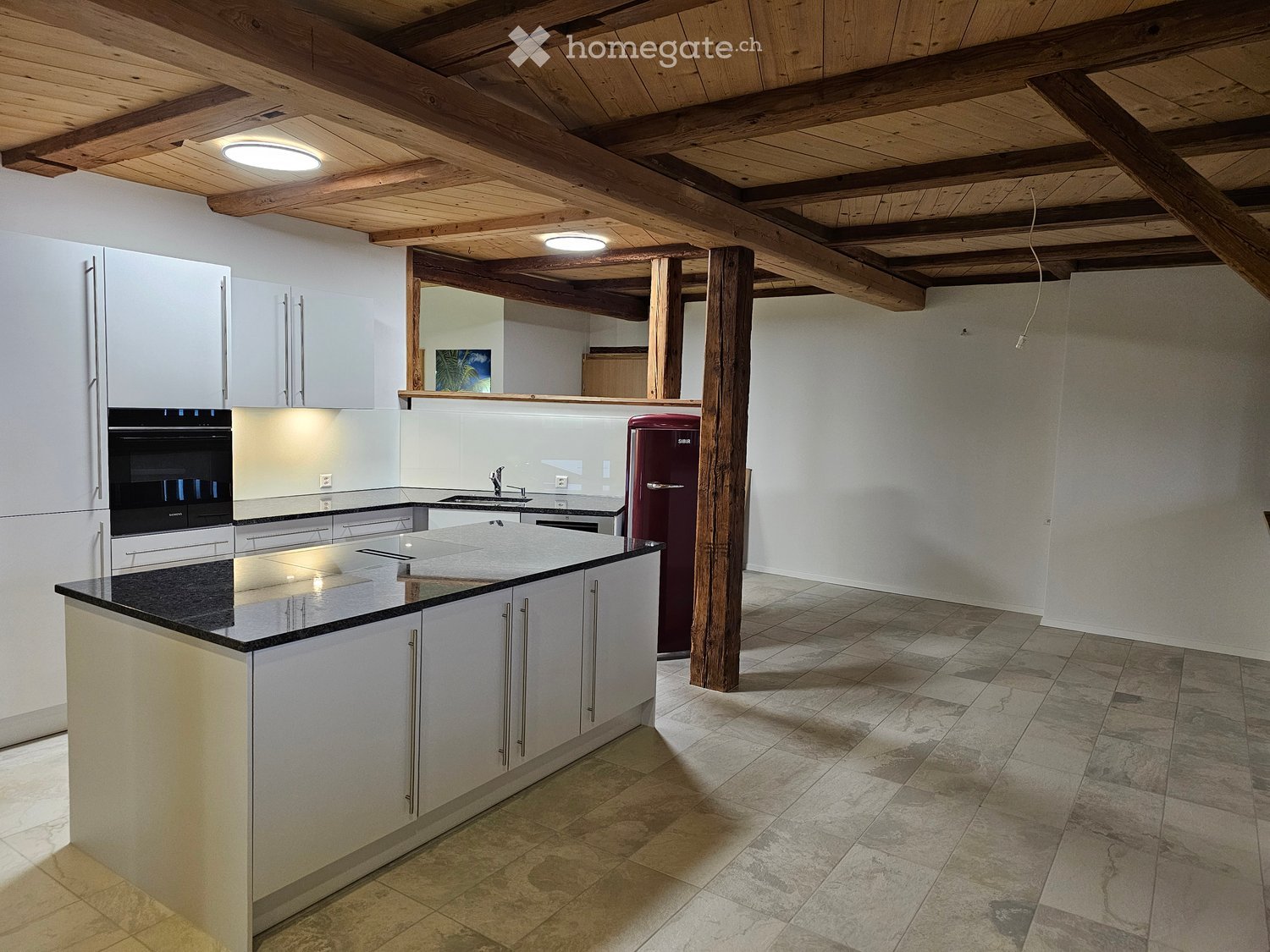 modern kitchen, island with granite counter, white cabinets, red refrigerator, ceiling lamps, tile flooring