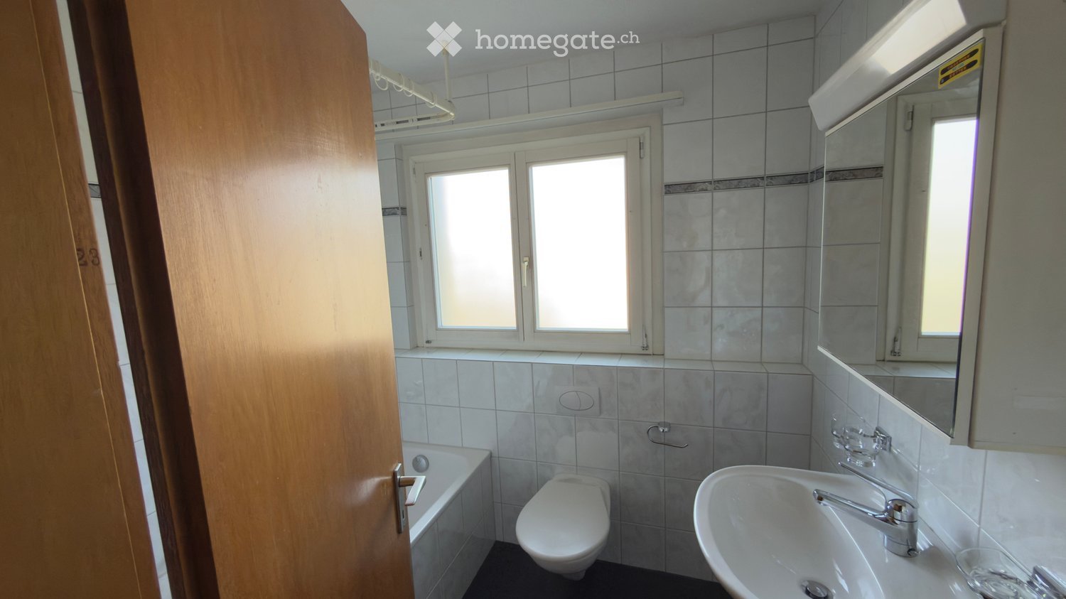 white tiled walls and floors, white bathtub, white toilet, white sink, white mirror