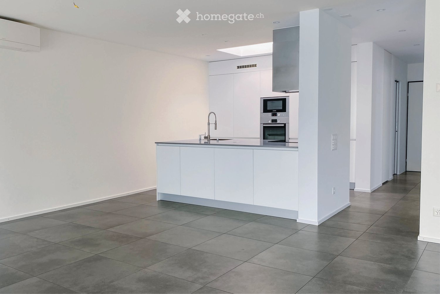 Modern kitchen with white cabinets, stainless steel appliances, and a central island with a sink and faucet.