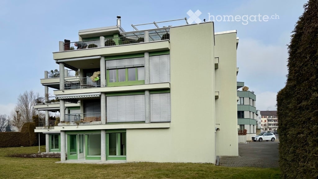 Apartment building, 3 stories, balconies, green frames around windows