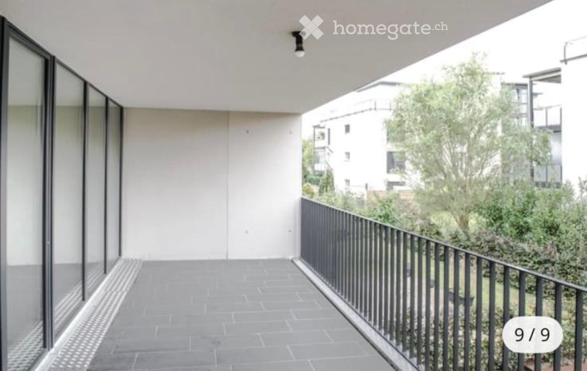 Modern building with glass exterior, concrete flooring, white walls, steel railing, glass walls