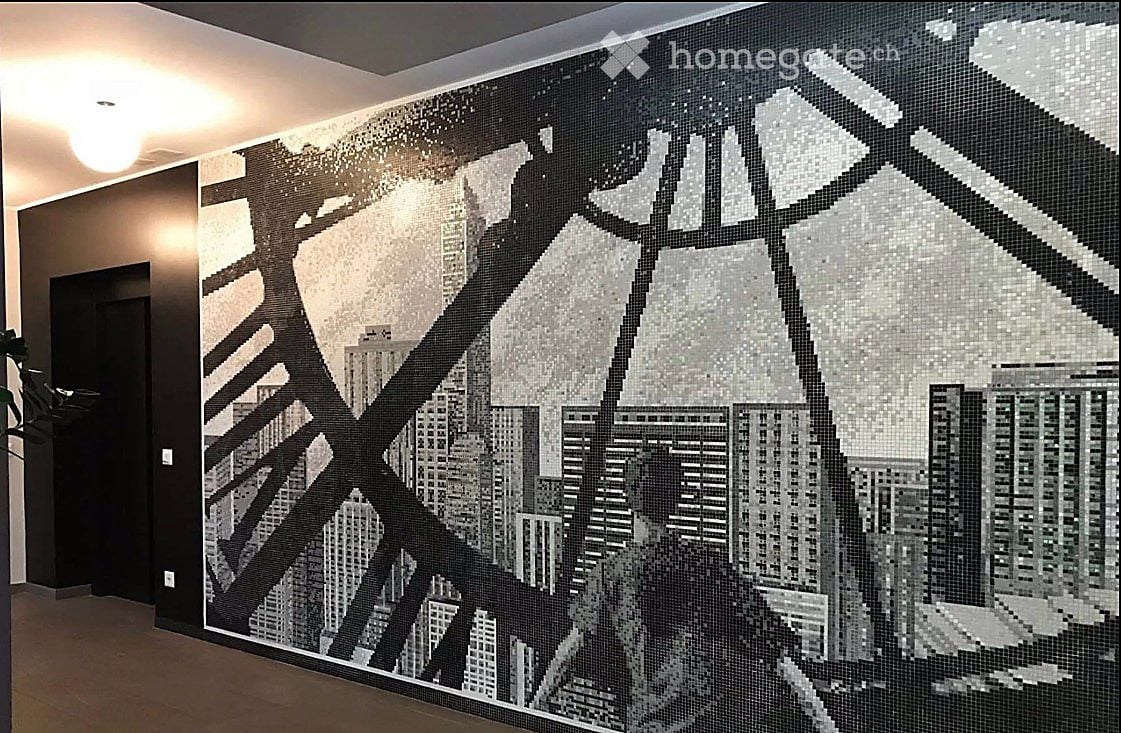 Hallway with a large mosaic mural depicting a cityscape, featuring geometric shapes and architectural elements.