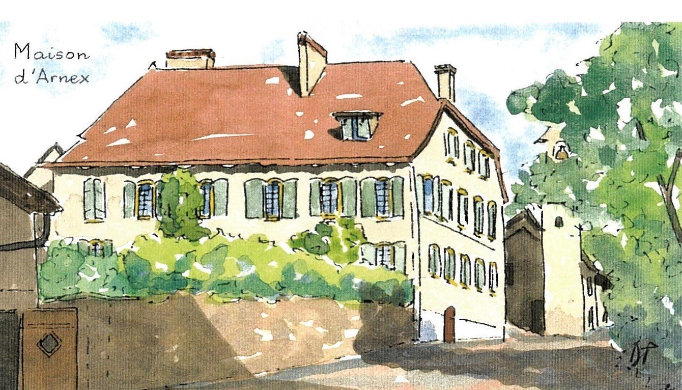 A two-story building with a red-tiled roof, multiple windows, and a small garden area in front.