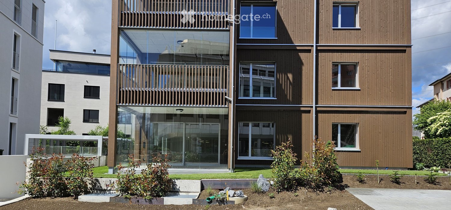 Building. Modern multi-story building with wooden facade, large windows, and balconies.