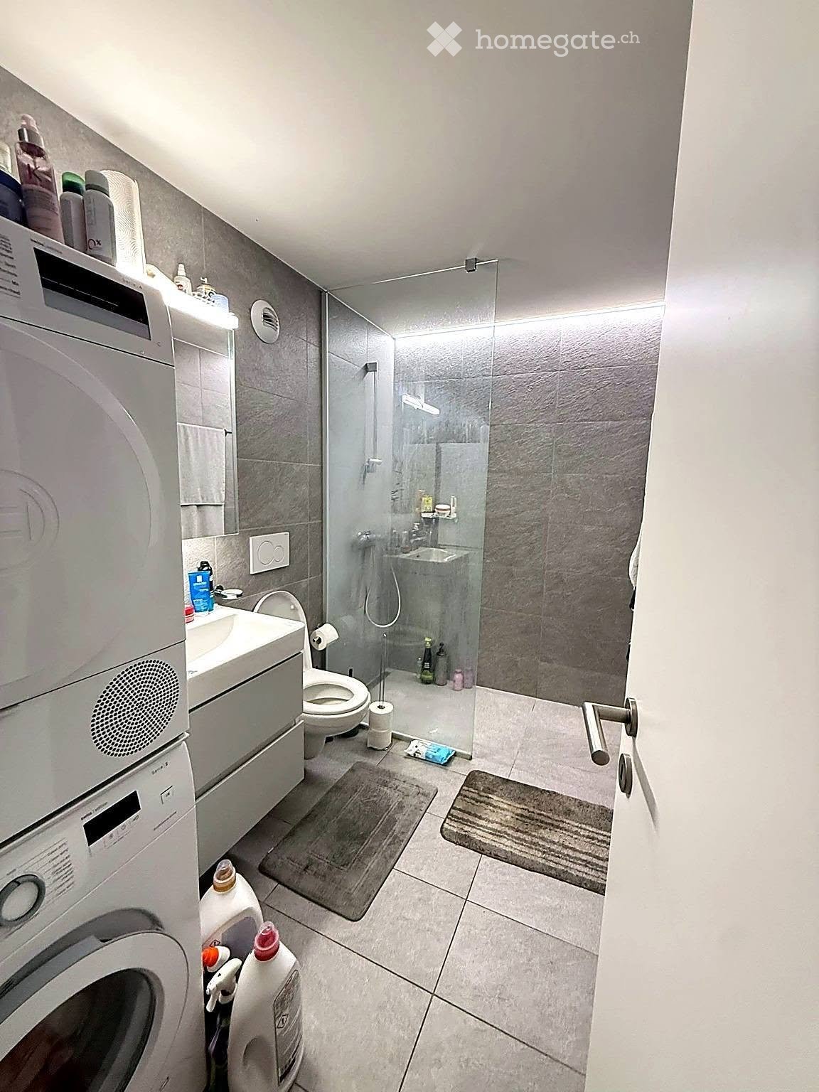 {"visible_features": ["Private washing machine"], "type": "Bathroom", "objects": ["toilet", "sink", "shower", "washing machine", "bottle", "bottle", "bottle", "bottle", "bottle", "bottle", "bottle", "bottle", "bottle", "bottle", "bottle", "bottle", "bottl