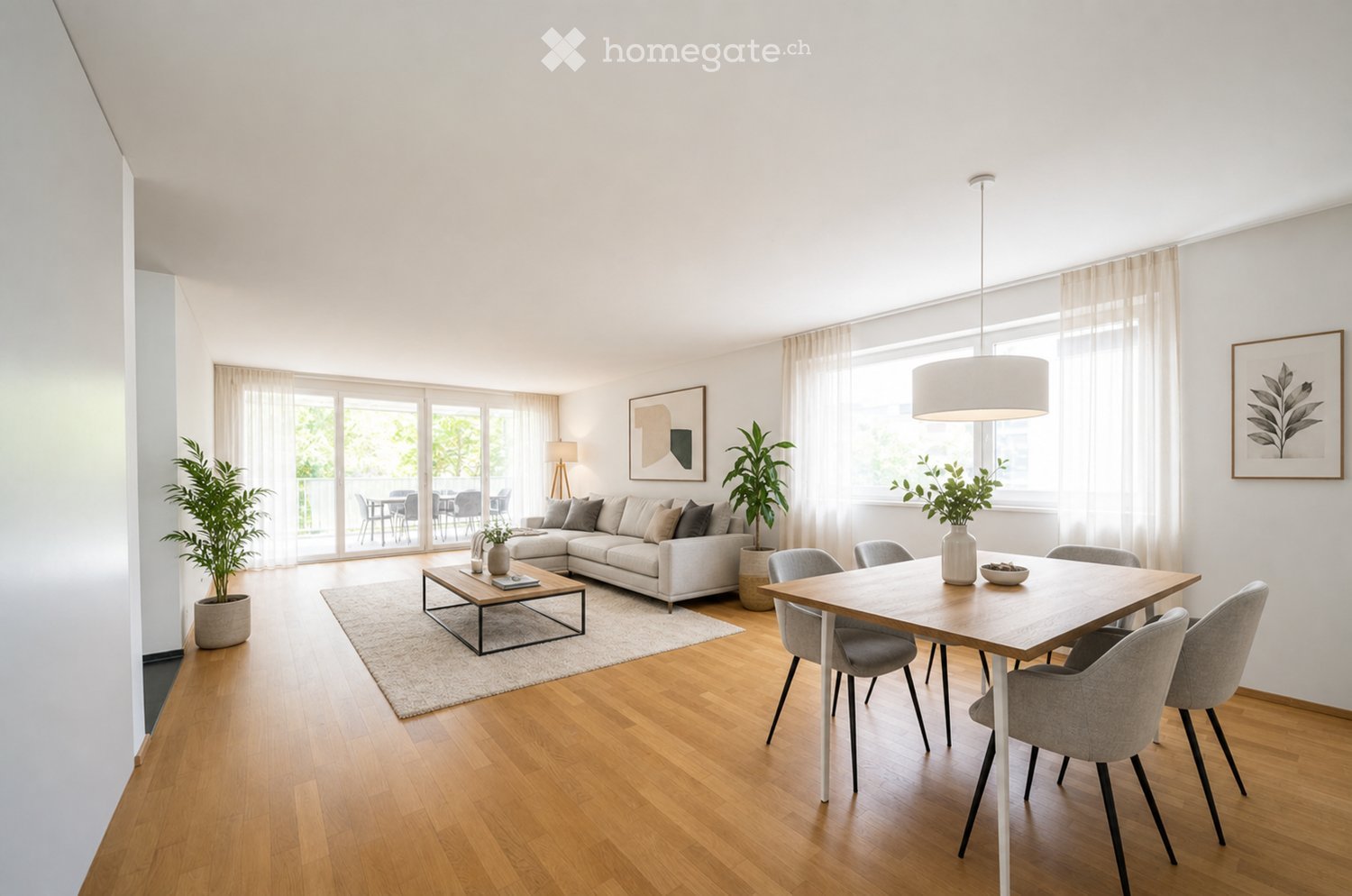 Bright living and dining area with wooden flooring, large windows, and a balcony. Features a sectional sofa, coffee table, dining table with chairs, and decorative plants.