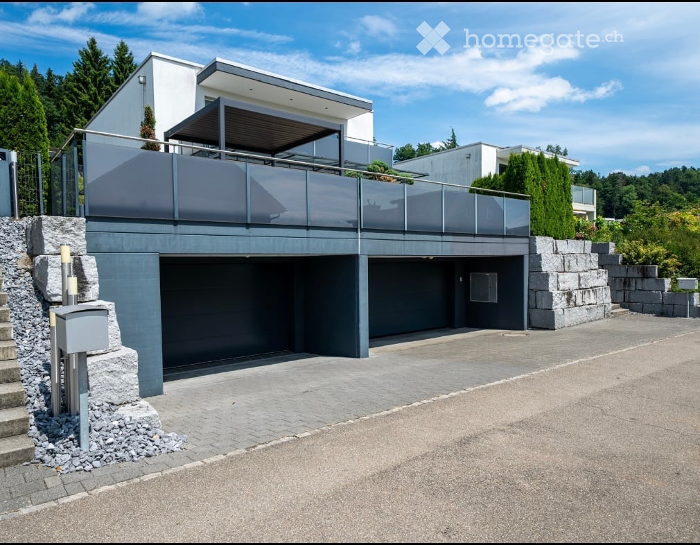House with double garage, balcony with canopy, grey stone wall, modern architecture