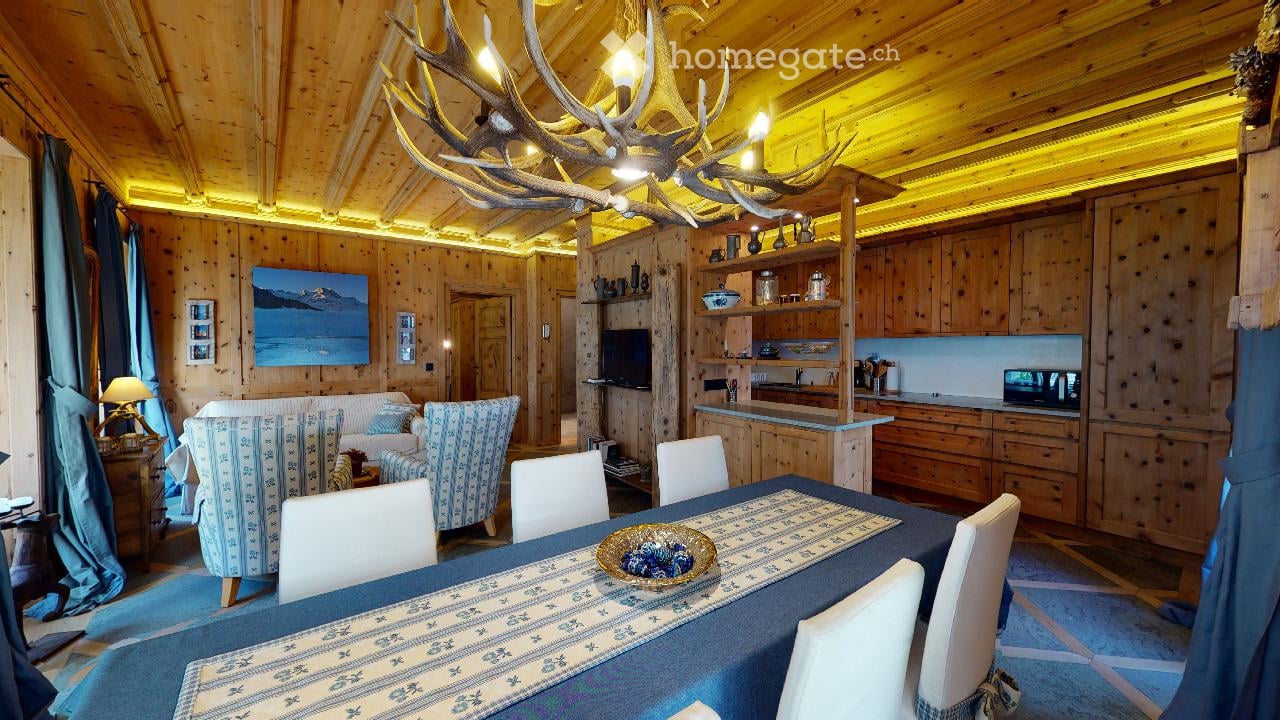 wooden floor, dining table, blue curtain, deer antlers chandelier, white couch, kitchen