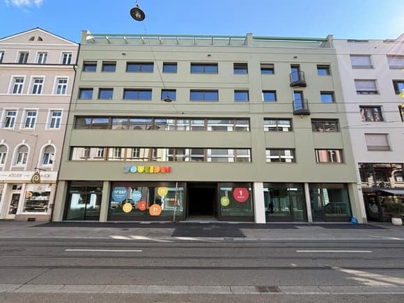 4 story building, glass windows, glass doors, balcony on 2nd floor, street view